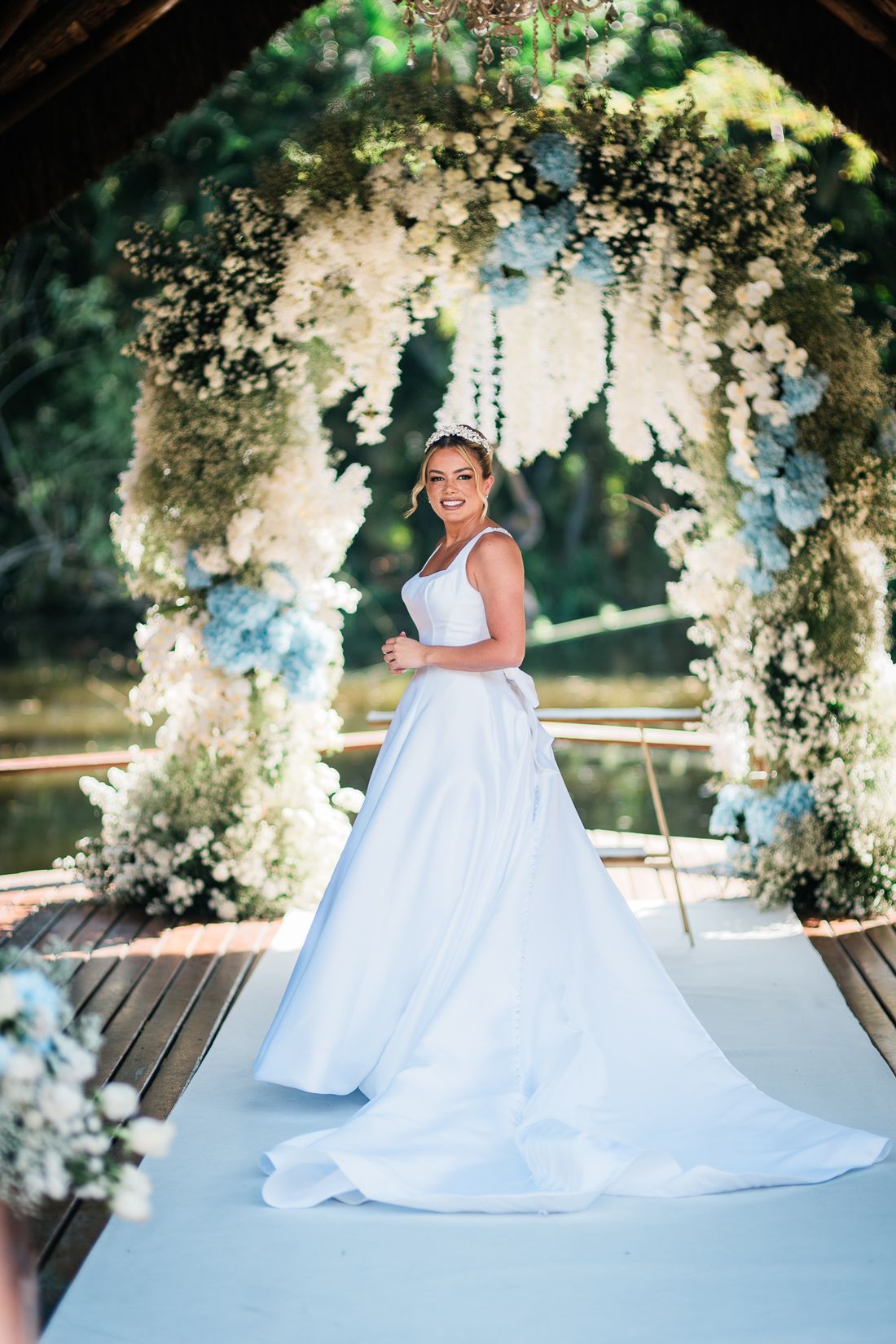 Noiva sob arco floral com maquiagem iluminada