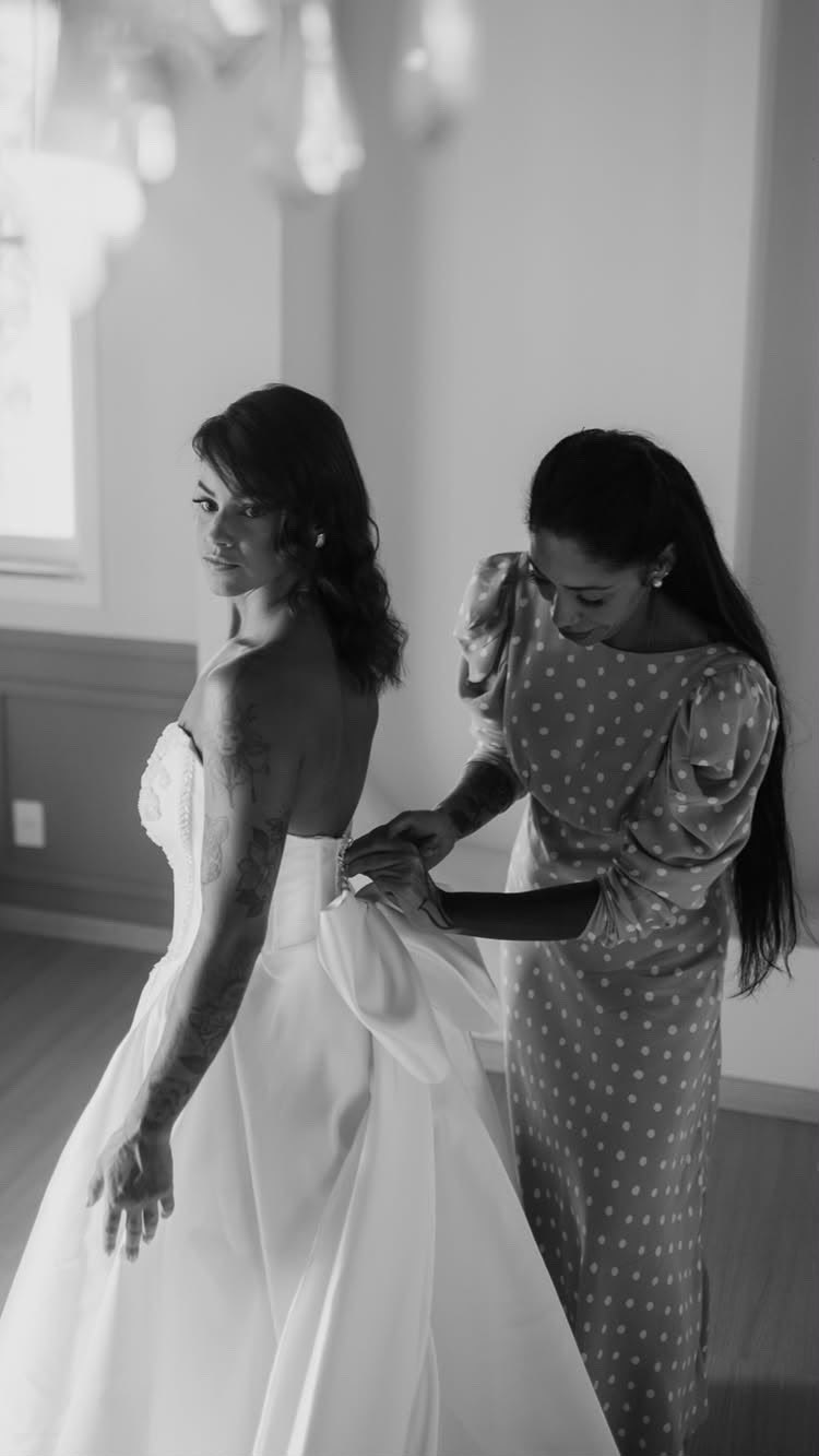 Natasha ajustando o laço do vestido da noiva